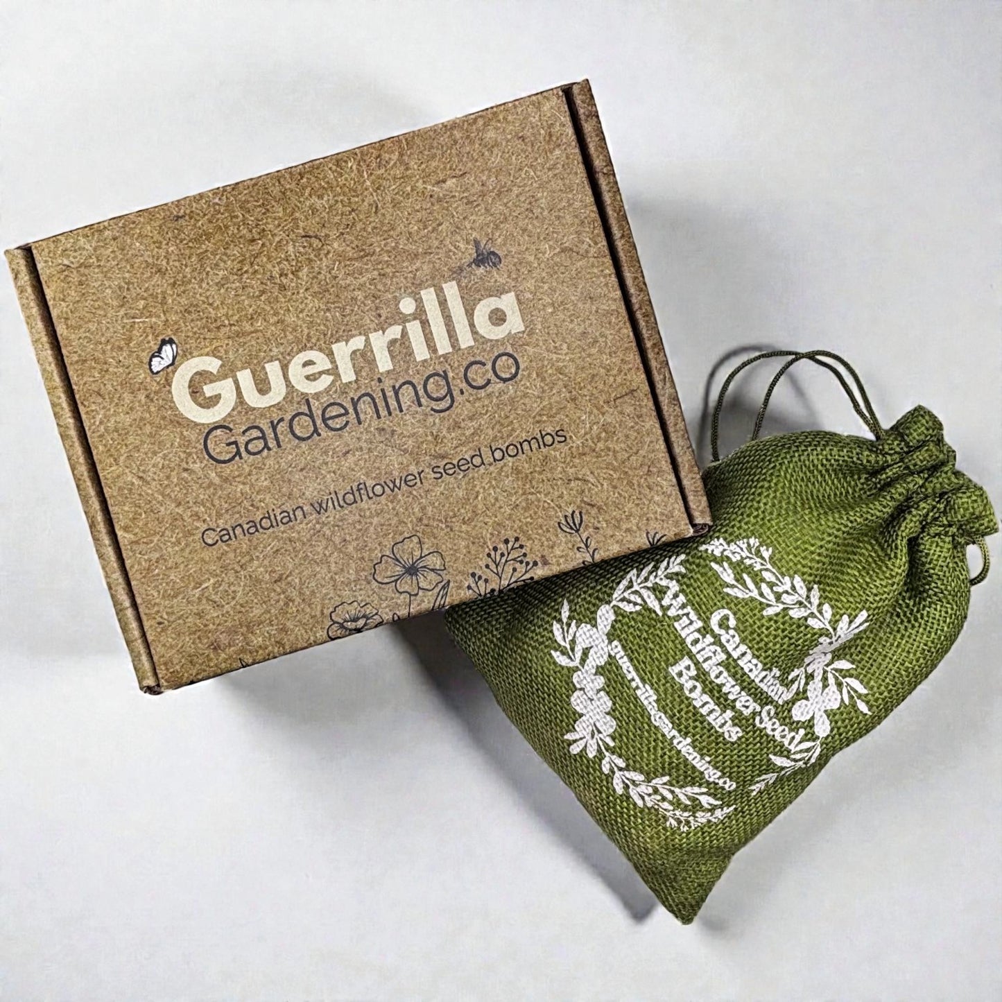 
                  
                    Complete Guerrilla Gardening Kit: stamped brown cardboard shipping box and green burlap bag containing cans of Canadian wildflower seeds
                  
                